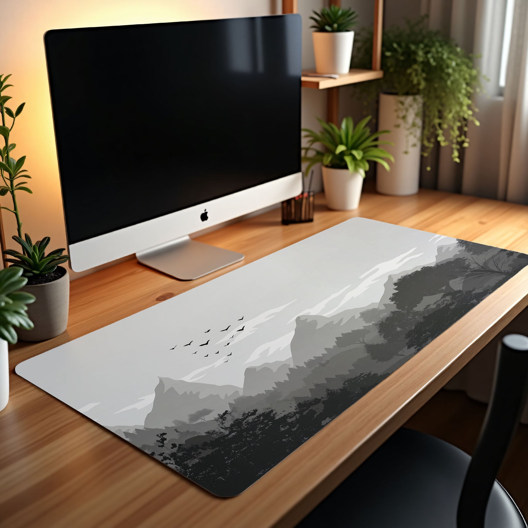 Desk setup with a computer monitor, mouse, and large desk mat on a wooden desk.