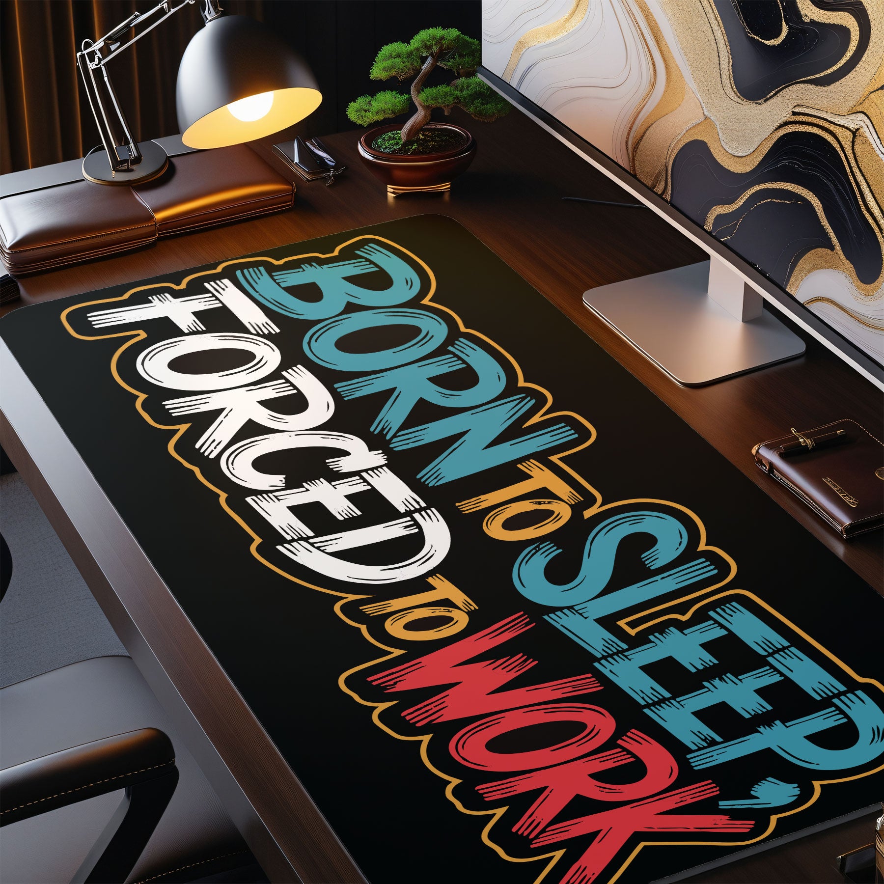Desk setup with a colorful 'Born to Sleep, Forced to Work' mouse pad.