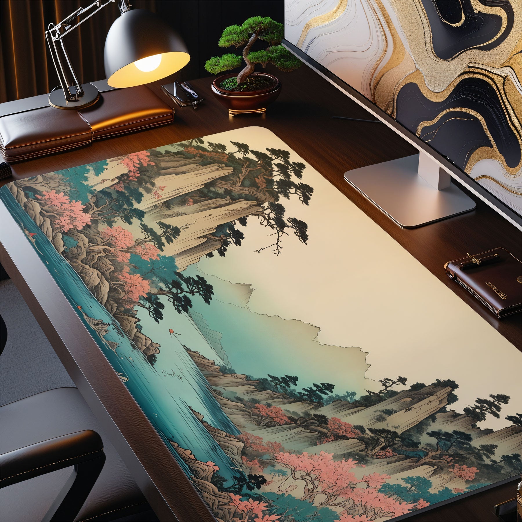Desk setup with a large desk mat featuring a scenic design, computer monitor, lamp, and office chair.